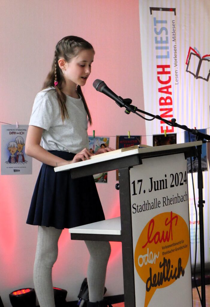 Henriette steht lesend am Rednerpult vor dem Mikrophon und liest aus dem Herrn der Diebe - Foto Gerd Engel